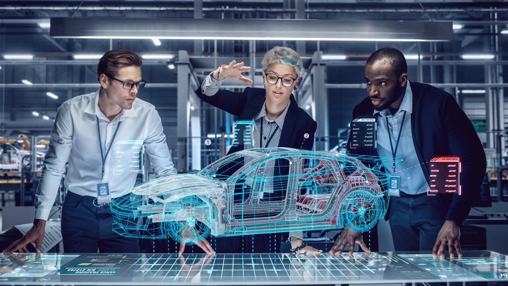 Drei Ingenieure untersuchen in einem modernen Labor ein projiziertes 3D-Hologramm eines Autos auf einem digitalen Tisch, interagieren mit dem virtuellen Modell und diskutieren über dessen Design und Datenpunkte.