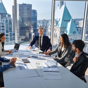 Senior executives participating in board-level training session with strategic documents in a high-rise meeting room