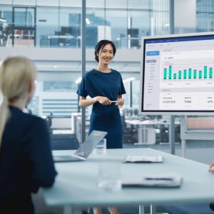 Professional presenting growth and sales analytics to senior executives during a business development training