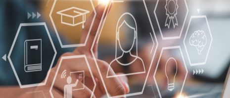 Person interacting with virtual icons representing digital learning, certification, and innovation on a laptop screen